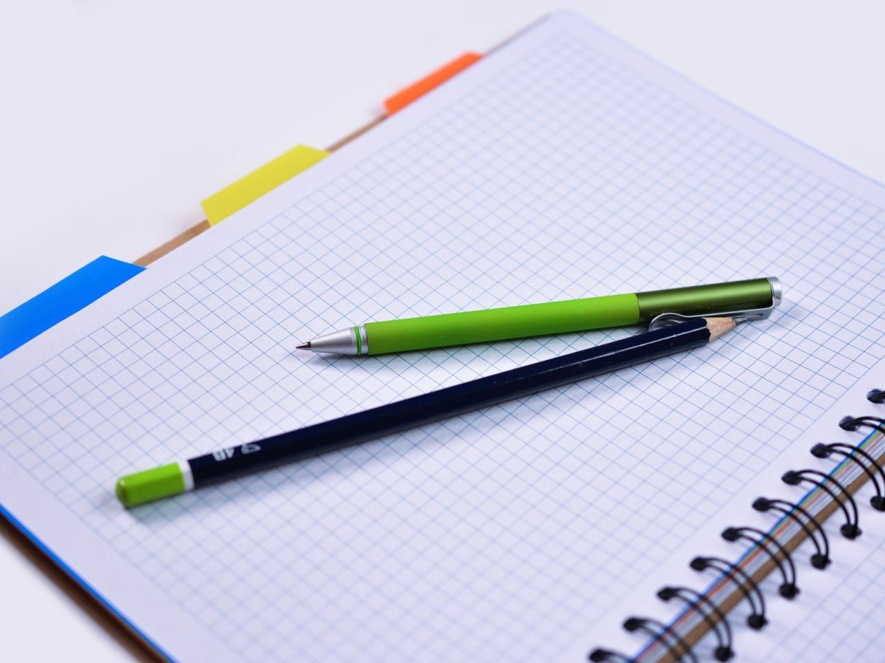 Een potlood en pen op een ruitjesschrift