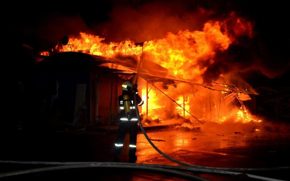 Een brandweerman blust een brandend gebouw