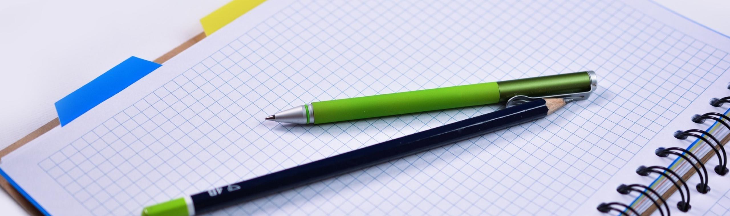 Een potlood en pen op een ruitjesschrift